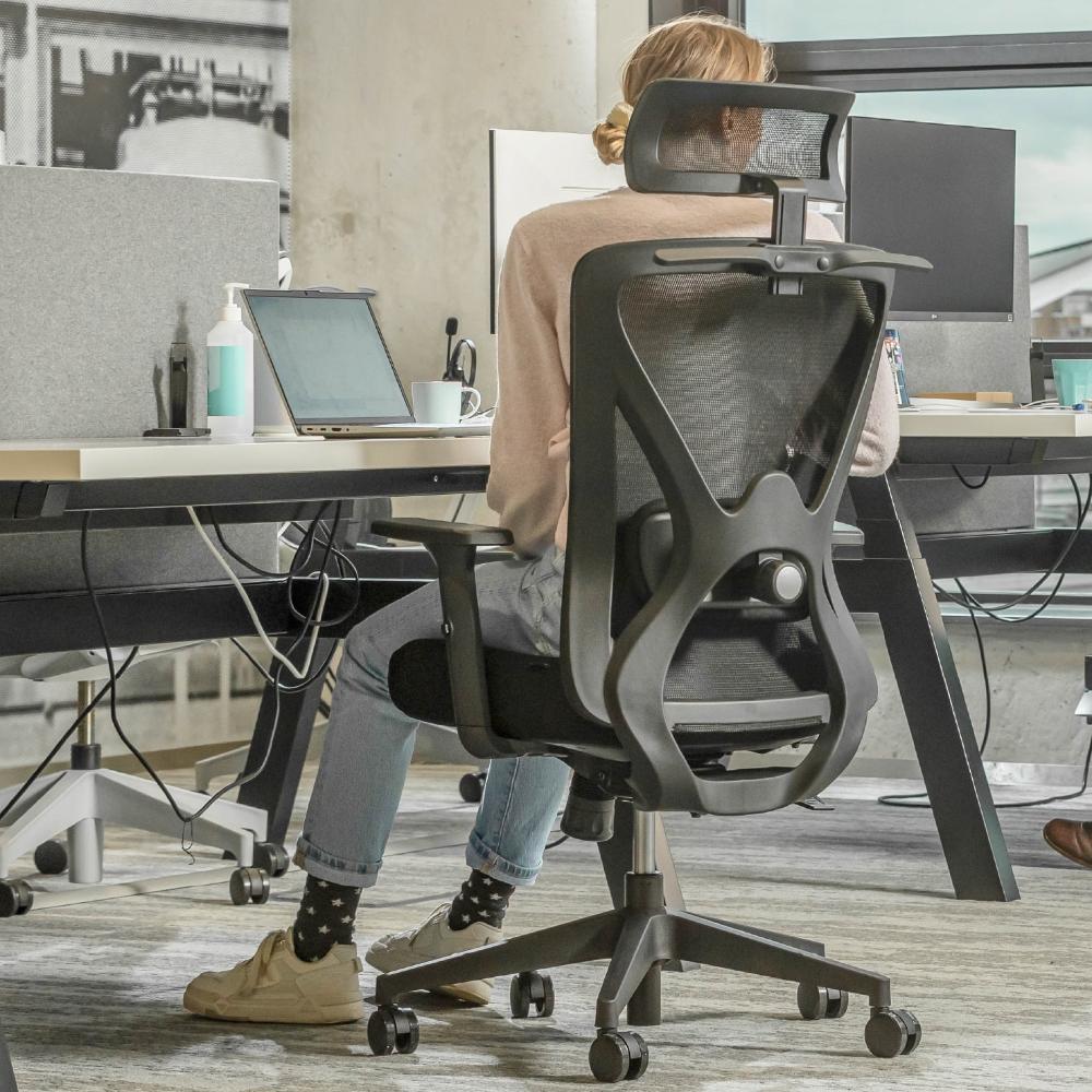 Een persoon zit aan een bureau met een computer in een comfortabele Backerz Motion Mesh Office Chair.