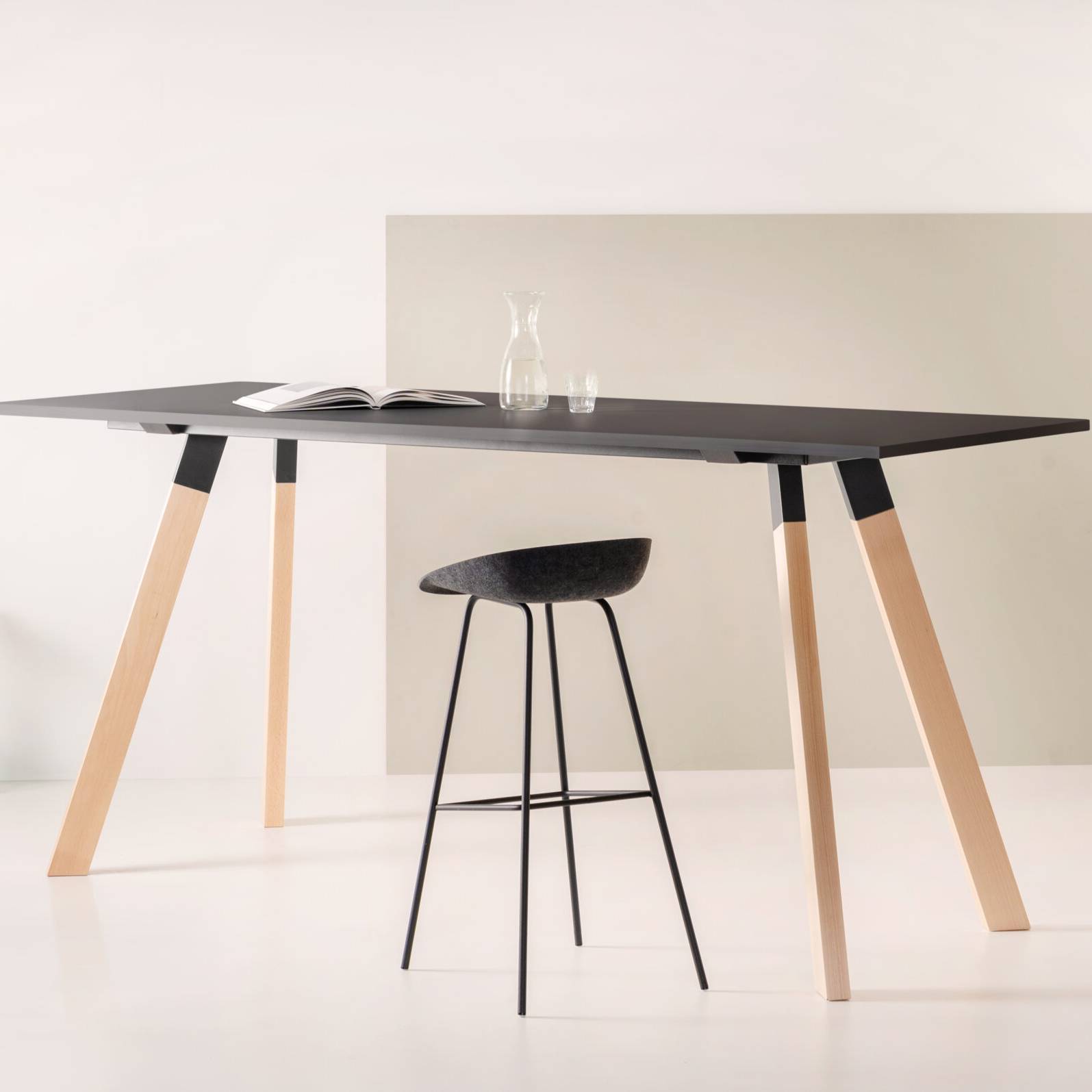 Duurzame zwarte kruk met een zwart frame, vervaardigd uit gerecycled materiaal voor een moderne en milieuvriendelijke look.